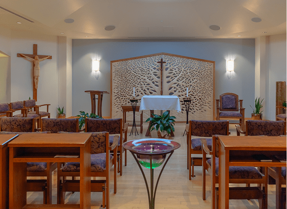 Modern chapel interior with altar and seating.