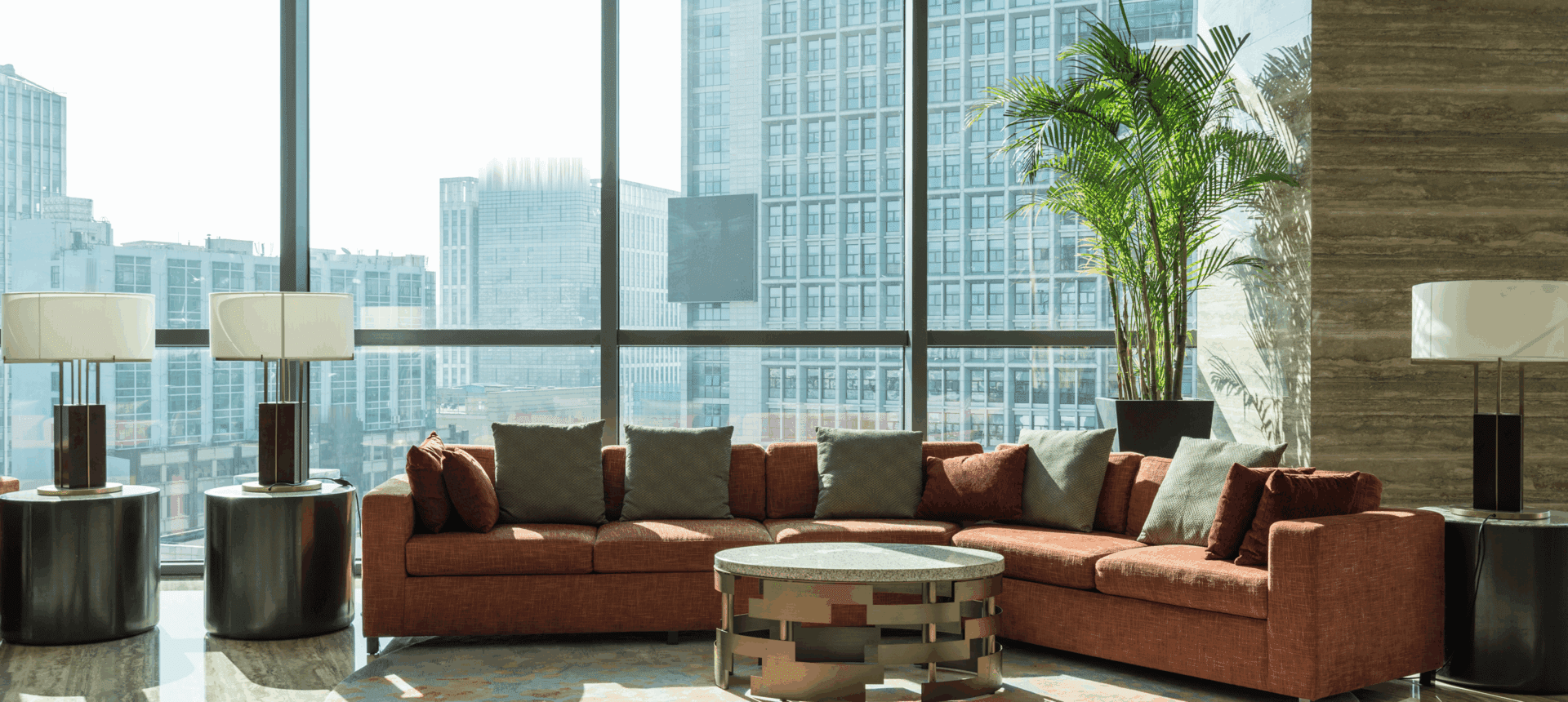 Modern lounge with large windows and sofa.